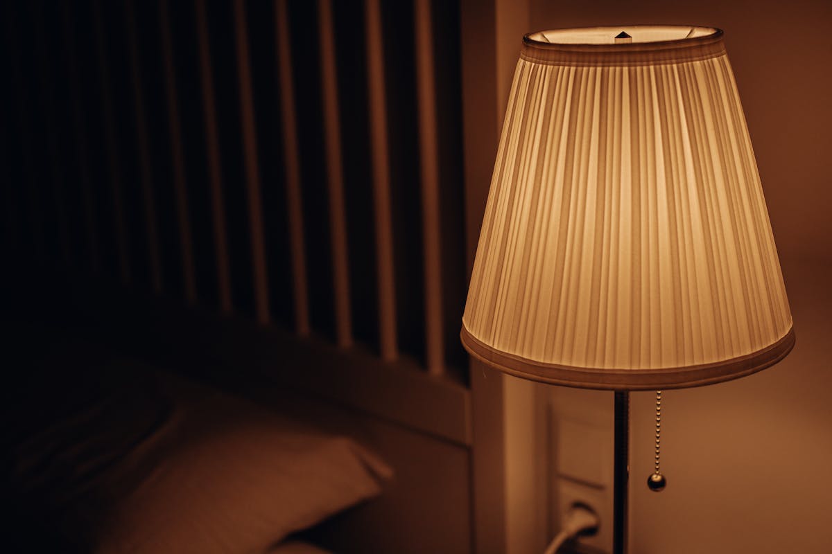 Aurora LED Sunset Projection Lamp casting warm golden glow in bedroom