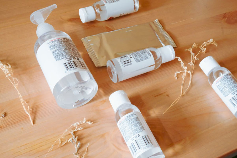 Travel hygiene kit flatlay with hand sanitizer and small travel toiletry bottles laid out