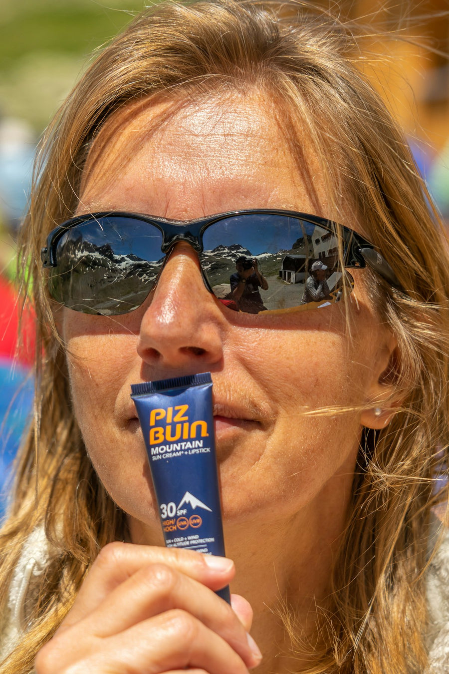 Person applying a mineral sunscreen stick outdoors in the sun